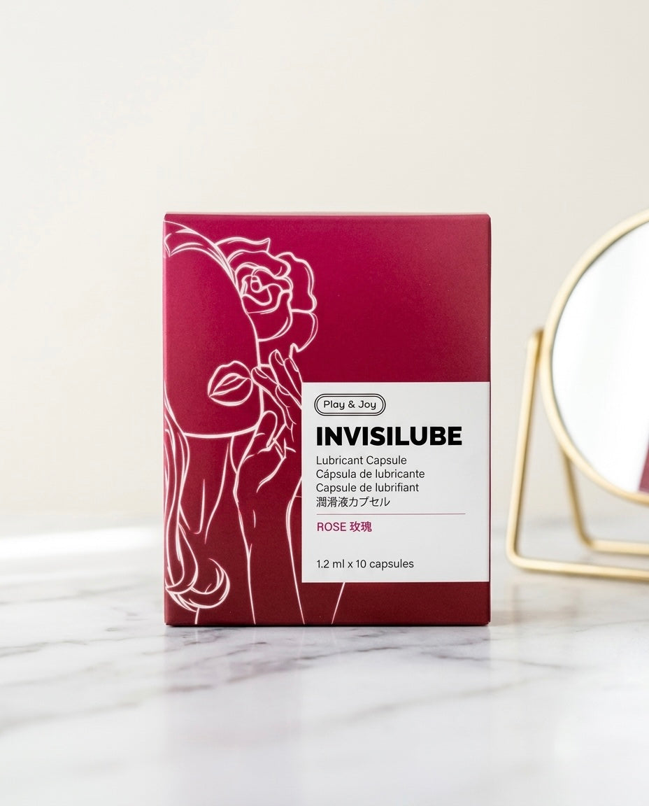 Cápsulas monodosis Invisilube sobre una superficie de mármol blanco, junto a un espejo dorado de fondo.