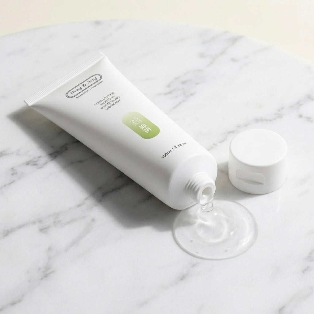 Plano detalle del dosificador mostrando la textura en gel transparente base agua del Lubricante Antibacteriano cayendo sobre mármol.